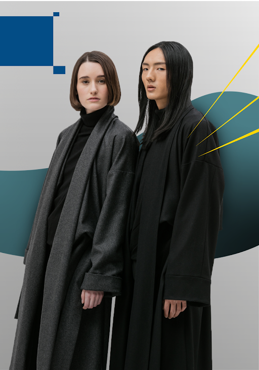 A female and a male model standing next to each other wearing designer black and grey coats.